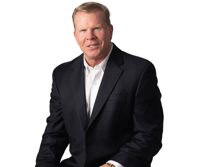 Smiling man in a dark suit and white shirt, seated confidently. CEO of Advanced Digital Automotive Group.