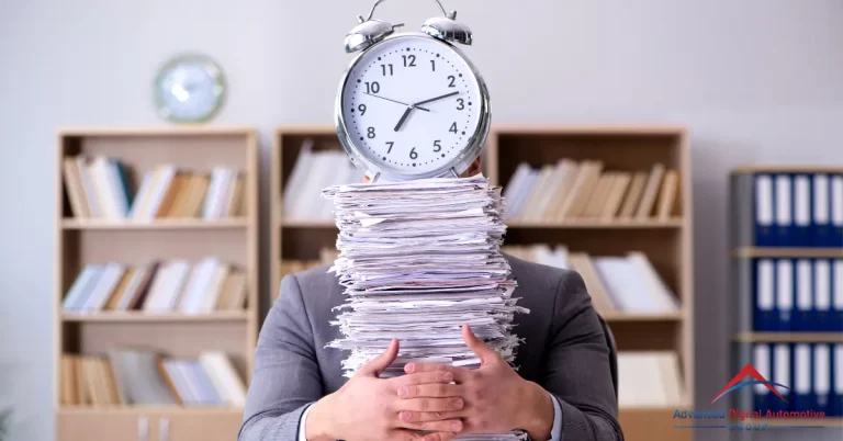 Man embracing a pile of paperwork with an alarm clock on top.